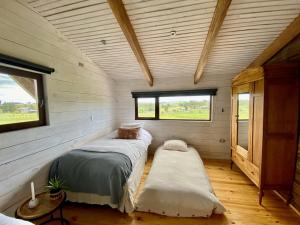 dwa łóżka w małym pokoju w domu w obiekcie Cabaña con chimenea en Pto Varas w mieście Puerto Varas