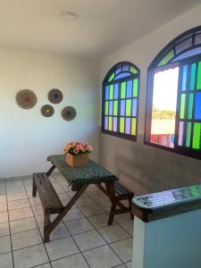 a room with a table and stained glass windows at Casa 2 quartos praia de Jacaraípe. in Serra