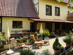 une terrasse avec des chaises et des plantes en pot en face d'une maison dans l'établissement Maison de vacances Alsace - Ferienhaus Elsaß - Holiday house Alsace, à Bischwiller