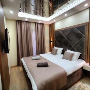 una camera da letto con un grande letto con una grande testiera di Harmony Apartments a Podgorica
