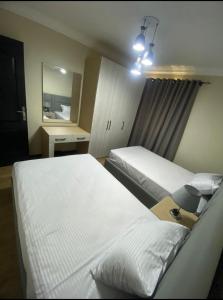 Cette chambre comprend 2 lits et un miroir. dans l'établissement Ocean Blue Luxury serviced Hotel Apartments, au Caire