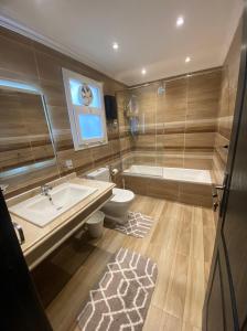 La salle de bains est pourvue d'une baignoire, d'un lavabo et de toilettes. dans l'établissement Ocean Blue Luxury serviced Hotel Apartments, au Caire