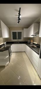 カイロにあるNearest Luxurious Compound to Cairo Int Airportのキッチン(白いキャビネット、天井ファン付)