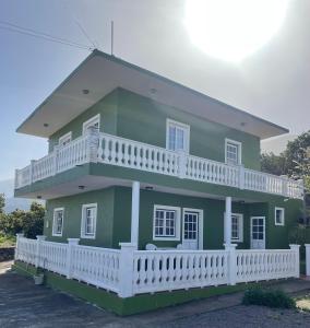 une maison verte avec un balcon blanc. dans l'établissement Casa Feluca, à Breña Alta