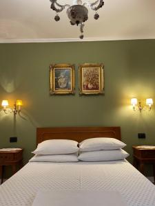 ein Schlafzimmer mit einem Bett mit zwei Bildern an der Wand in der Unterkunft Vintage Apartment in Pristina