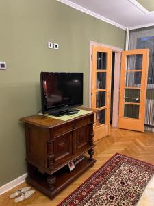ein Wohnzimmer mit einem Flachbild-TV auf einem Holztisch in der Unterkunft Vintage Apartment in Pristina