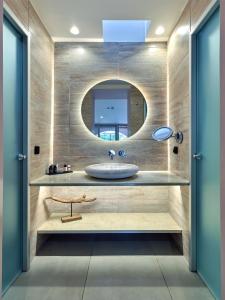 a bathroom with a sink and a mirror at ISAVORIA ECO CHIC RESORT in Parga