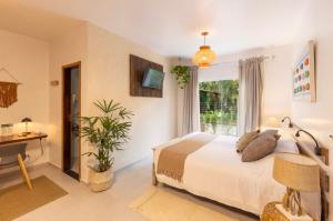 a bedroom with a bed and a desk and a window at Itamambuca Eco Resort in Ubatuba +111 photos