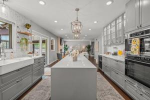 una grande cucina con un bancone bianco ed elettrodomestici di Zestlife-LuxuryEscape-ThemedRooms-Pool-GameRoom a Indianapolis
