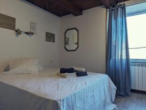 Schlafzimmer mit einem Bett mit einem Spiegel und einem Fenster in der Unterkunft Le Logis Fleuri 