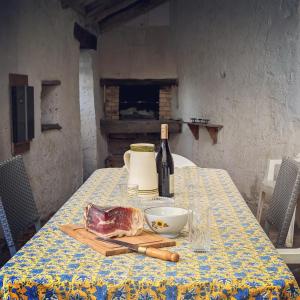 einen Tisch mit einer Flasche Wein und einem Laib Fleisch in der Unterkunft Le Logis Fleuri 