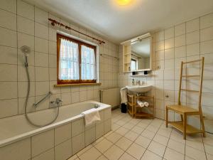 a bathroom with a bath tub and a sink at Bauernchalet Alois in Dornbirn