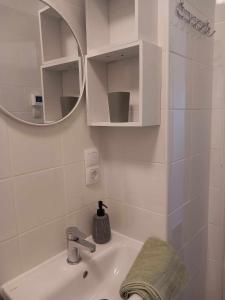 Baño blanco con lavabo y espejo en Bükki csend vendégház, en Bükkszentkereszt