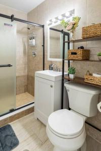 a bathroom with a toilet and a sink and a shower at Seaside Escape Steps to Beach, Dining, Shopping and Las Olas! in Fort Lauderdale