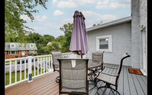 a patio with an umbrella and chairs on a deck at Splendid Cheerful 2-bedroom residential in Hyattsville