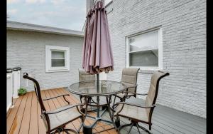 una mesa con sillas y una sombrilla en una terraza en Splendid Cheerful 2-bedroom residential en Hyattsville