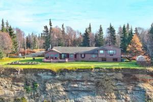 a large house on a hill with a yard at Kenai Vacation Rental with Volcano and Glacier Views! in Kenai