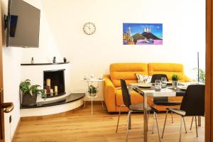 een woonkamer met een gele bank en een tafel bij Re Nasone Guest House in Napels