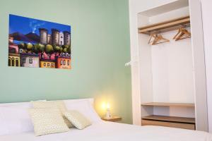 een slaapkamer met een bed en een schilderij aan de muur bij Re Nasone Guest House in Napels