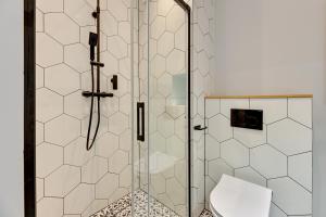 a shower stall with a toilet in a bathroom at Wyspa Spichrzów Residence in Gdańsk