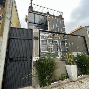 a house with a black gate and some plants at Estúdios Conteiners de 02 a 04 hóspedes região lapa in São Paulo