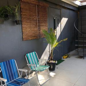 two chairs and a plant on a patio at Estúdios Conteiners de 02 a 04 hóspedes região lapa in São Paulo