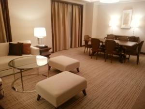 a living room with a couch and a dining room at JR Hotel Clement Tokushima in Tokushima