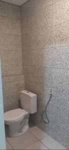 uma casa de banho com um WC e uma porta de duche em vidro. em Kitinet Central em Belo Horizonte