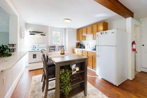 a kitchen with a table and a refrigerator at Vermont Marble Haven - Unit 2 in Rutland