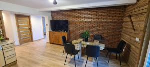 une salle à manger avec un mur en briques, une table et des chaises dans l'établissement Agroturystyka OAZA SPOKOJU, à Dynów