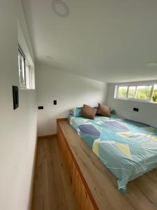 a bedroom with a bed with a comforter and a window at Tiny House Tauramena in Tauramena