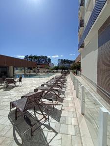 卡爾達斯諾瓦斯的住宿－Caldas Novas - 2024 - diRoma Spazzio acesso ao Vulcão - com Piscina do hotel 24 horas，坐在建筑物旁边的一排长椅