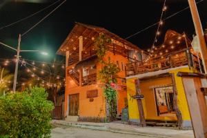 a yellow building with lights on a street at night at Tribu Hostel in Holbox Island