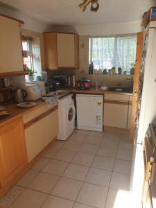 a kitchen with a washer and dryer in it at Harry Potter theme Double room in shared house in Garston