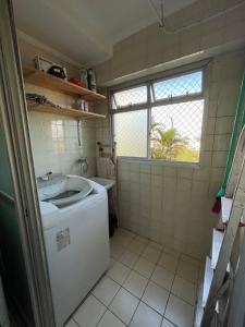 a small kitchen with a washing machine and a window at Apartamento próximo ao metro Jabaquara, apto 13 in São Paulo