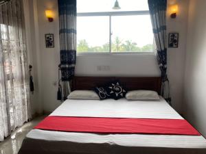 een slaapkamer met een bed en een groot raam bij JJ VILLA ALUTHGAMA in Aluthgama