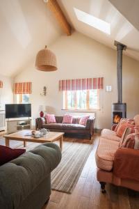 sala de estar con 2 sofás y chimenea en Otter's Cottage, en Holbeton