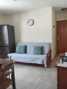 ein Wohnzimmer mit einem Sofa und einer Uhr an der Wand in der Unterkunft Casa Yuni in Candelaria