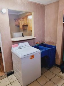 una pequeña cocina con fregadero azul y nevera. en apartamento equipado, en Amatitlán