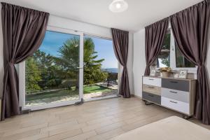 a bedroom with a large window with a view of the ocean at Villa Surina in Mošćenice
