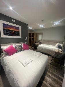 a hotel room with two beds with pink pillows at The Banks Restaurant and Accommodation in Strabane