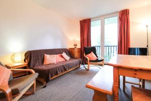 a living room with a couch and a balcony at Spacious Apartment Iris, Flaine Foret in Flaine