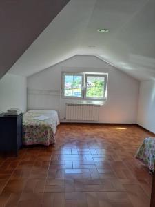 a attic room with two beds and a window at Casa Ares in Cee