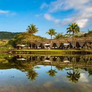 a resort with palm trees and a body of water at Itamambuca Eco Resort in Ubatuba