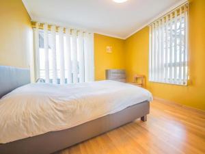 - une chambre avec un lit aux murs jaunes et des fenêtres dans l'établissement Les Terrasses Du Lac, à Vielsalm