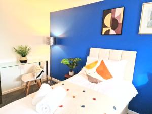 a bedroom with a blue accent wall and a bed at 1 Bed Central Serviced Accommodation with Balcony in Stevenage Free WIFI by Stay Local Home Welcome Contractors Business Travellers Families in Stevenage