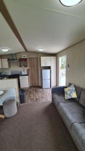 a living room with a couch and a kitchen at 8 Berth Luxury Caravan Butlins Holiday Village Skegness in Skegness