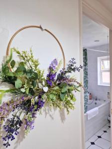 a wreath of flowers hanging on a wall in a bathroom at 1 Bed Central Serviced Accommodation with Balcony in Stevenage Free WIFI by Stay Local Home Welcome Contractors Business Travellers Families in Stevenage