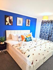um quarto com uma cama grande e uma parede azul em 1 Bed Central Serviced Accommodation with Balcony in Stevenage Free WIFI by Stay Local Home Welcome Contractors Business Travellers Families em Stevenage