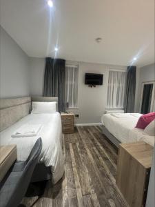 a hotel room with two beds and a television at The Banks Restaurant and Accommodation in Strabane